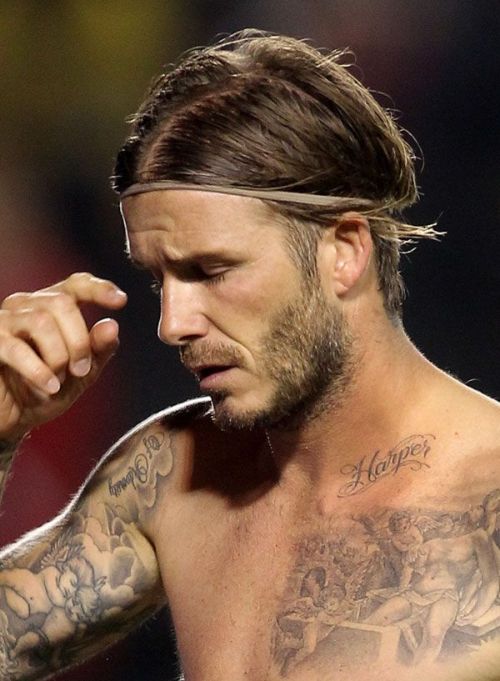 David Beckham shows off his new tattoo during a